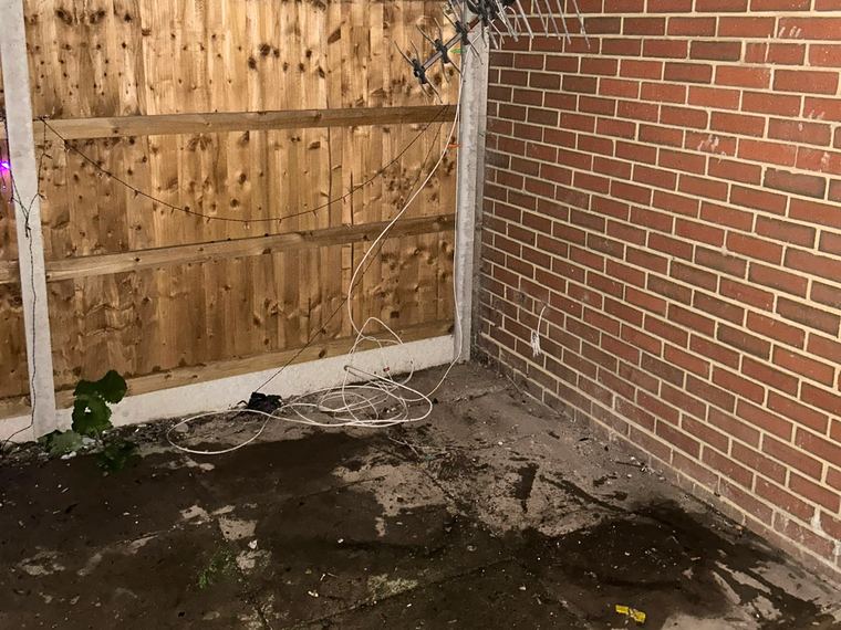 The same garden corner cleared to the paving slabs and fence