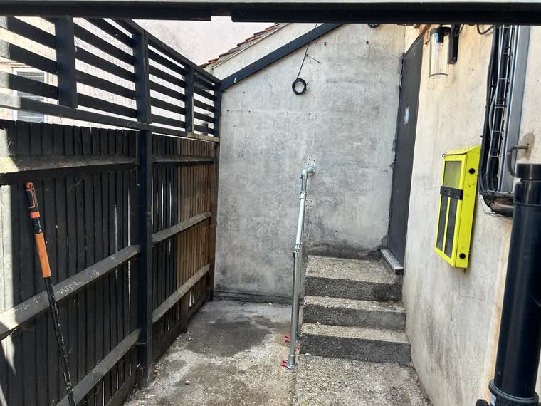 The same side yard emptied and swept, steps and access clear